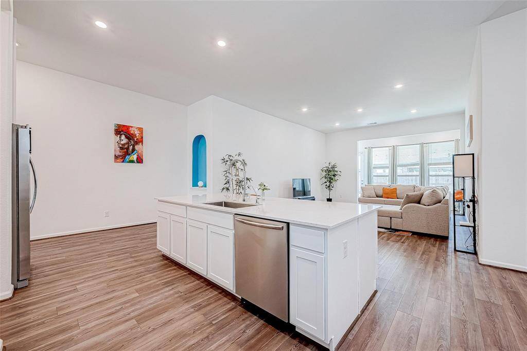 Kitchen features stainless steel appliances, sleek quartz countertops