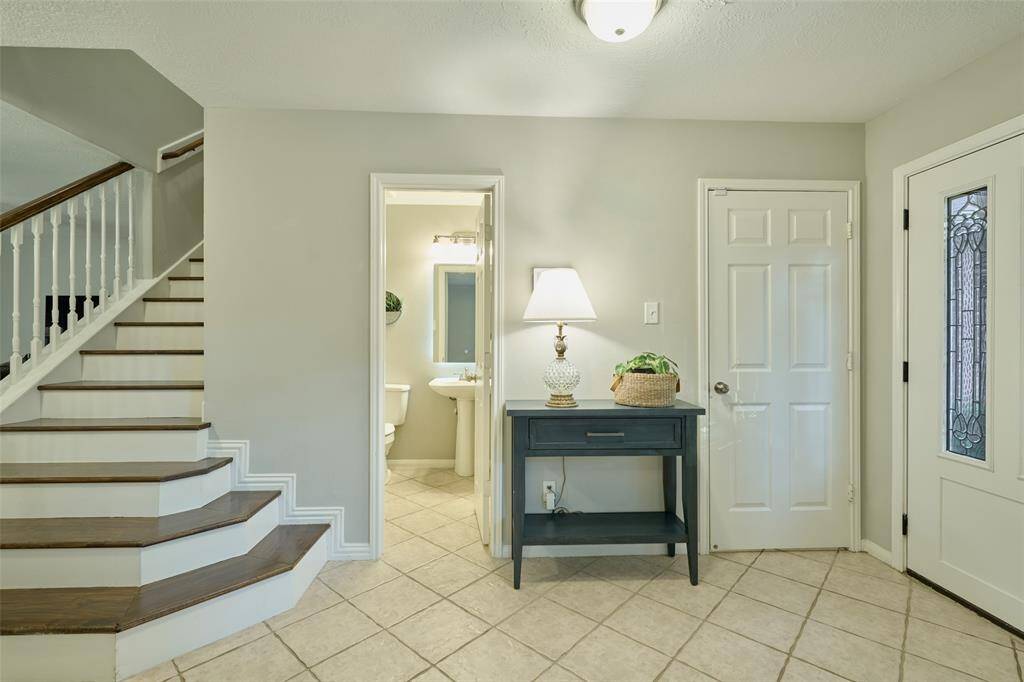 To the right of the entryway is the utility room and half bathroom. You are steps away from the beautiful wooden staircase.