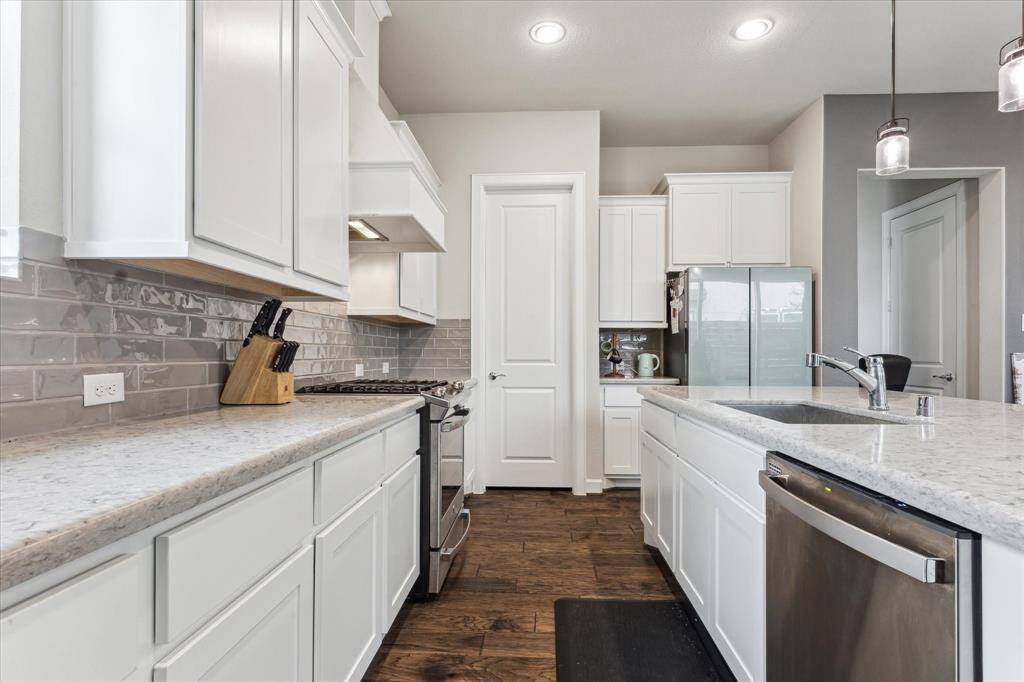 The kitchen showcases an attractive subway tile backsplash and modern appliances. The updated design combines style and functionality, creating a welcoming and efficient space for cooking and gathering. The backsplash adds a touch of elegance, while the newer appliances ensure that the kitchen is equipped to handle all your culinary needs with ease.