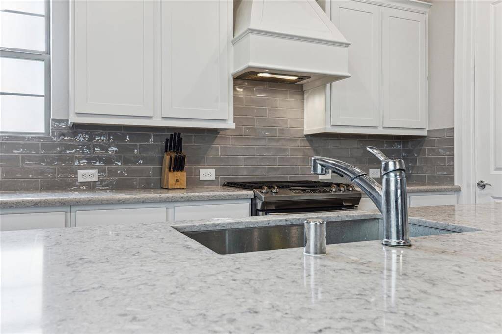 The bright and spacious kitchen features a sink situated in the island, offering a view of both the dining and living rooms.