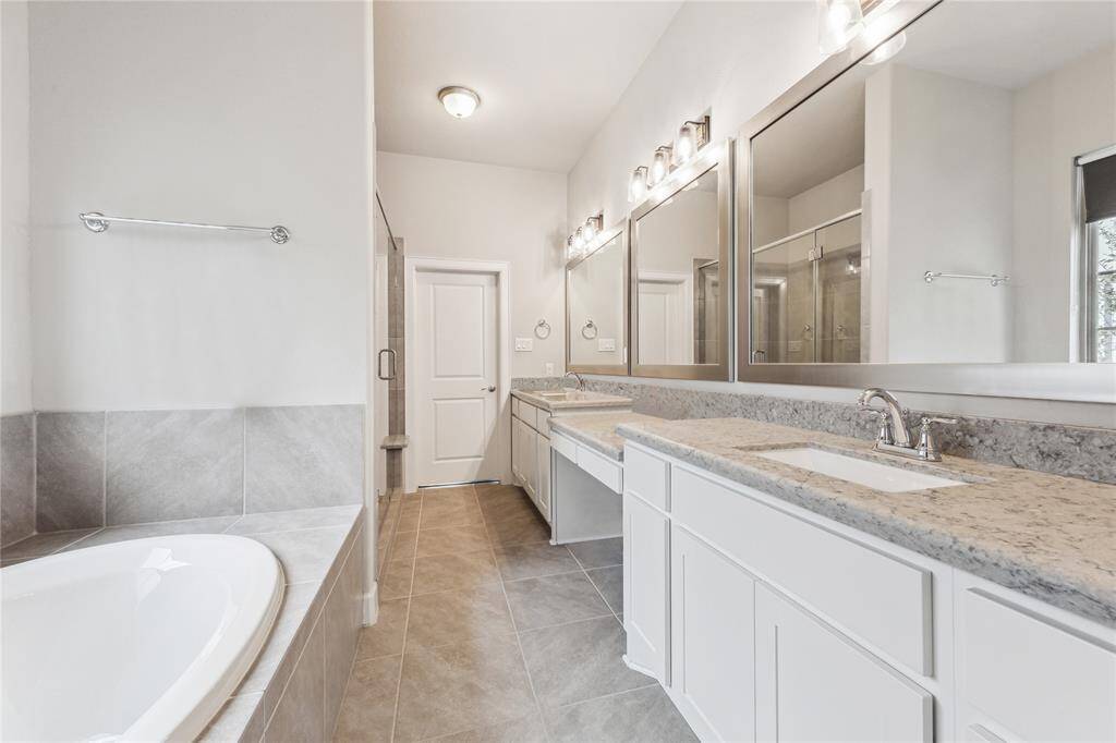 The image provides a clear view of the spacious main bathroom, highlighting a vanity area and two sinks. This setup suggests a design focused on both functionality and luxury, offering ample space for personal care routines. The layout ensures convenience and comfort, with enough room for multiple users to utilize the facilities simultaneously without feeling cramped.