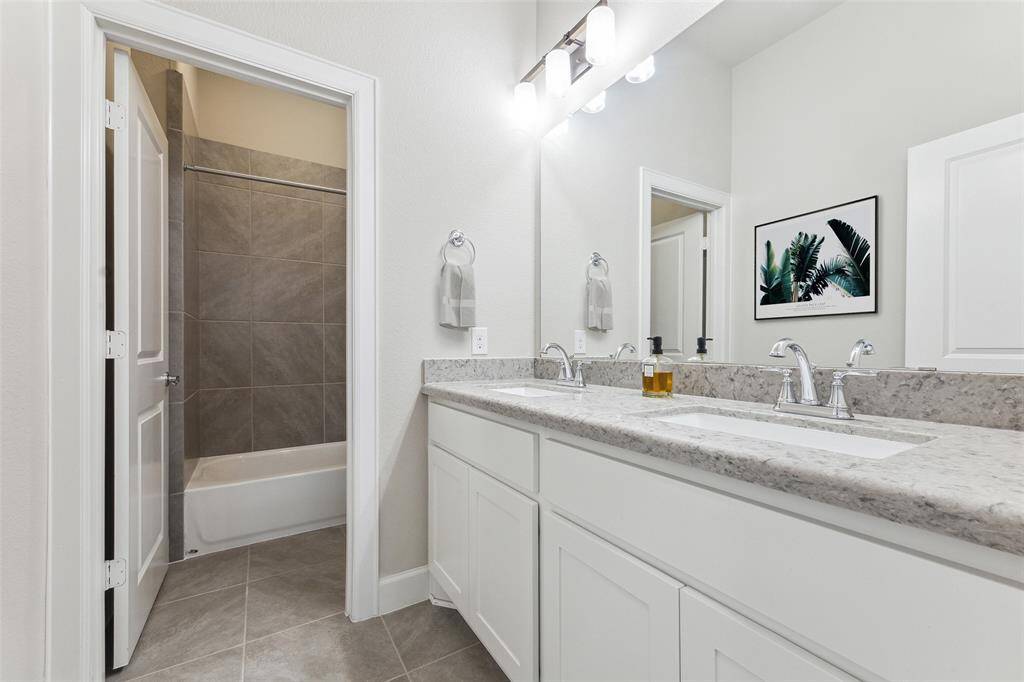 The secondary bathroom is strategically located between the two additional bedrooms and the laundry room. This thoughtful placement ensures convenient access for residents and guests alike, enhancing the overall functionality and flow of the home.