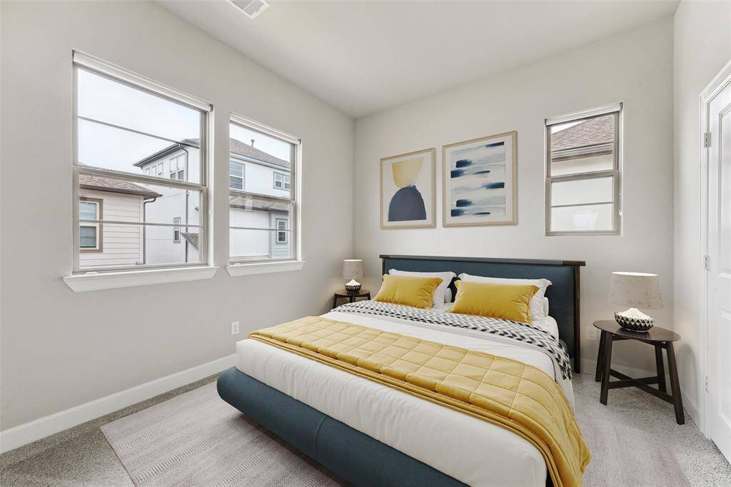 The second bedroom is filled with abundant natural light and features soft carpeted flooring. On the right side, there is a spacious closet offering ample storage space. (Digitally Staged)