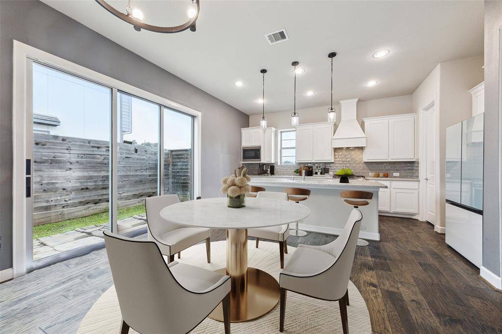 This spacious kitchen and dining area is ideal for entertaining guests. The sliding door opens to the backyard, providing easy access to outdoor gatherings. (Digitally Staged)
