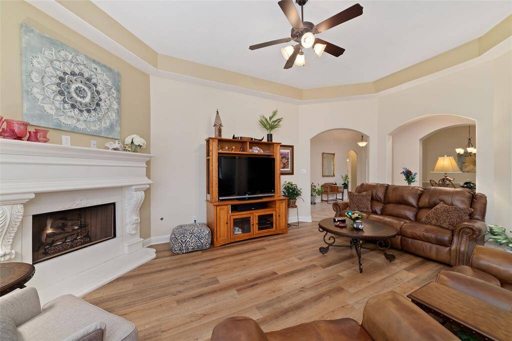 The spacious living room is warm and inviting, anchored by a cozy gas log fireplace that creates the perfect ambiance.