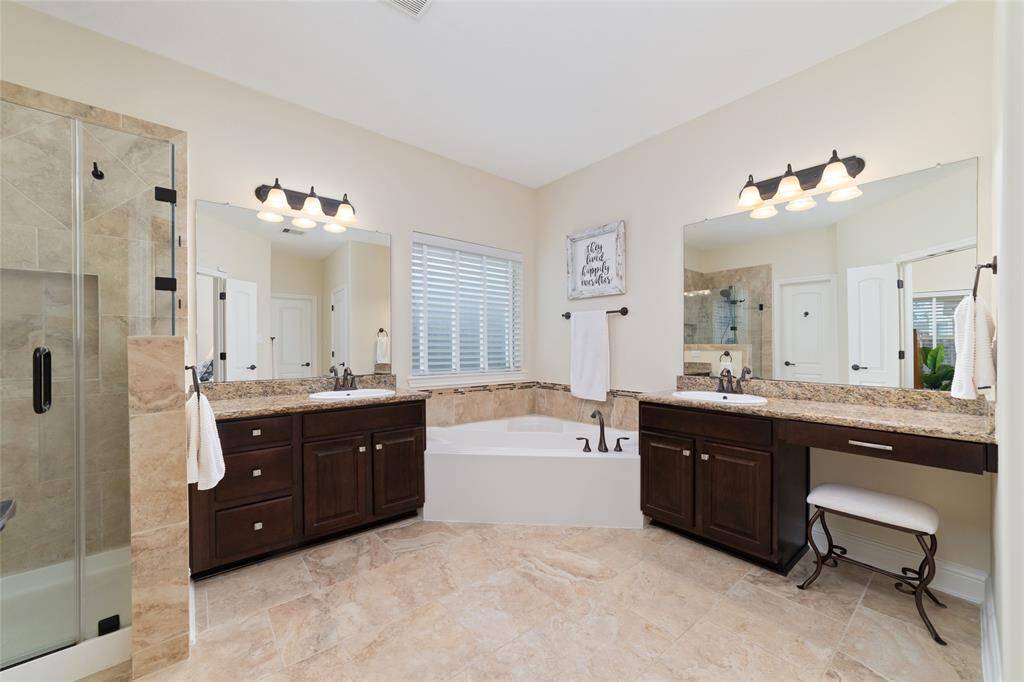 The primary bathroom is a true retreat, featuring dual vanities with sleek granite countertops for both style and convenience.