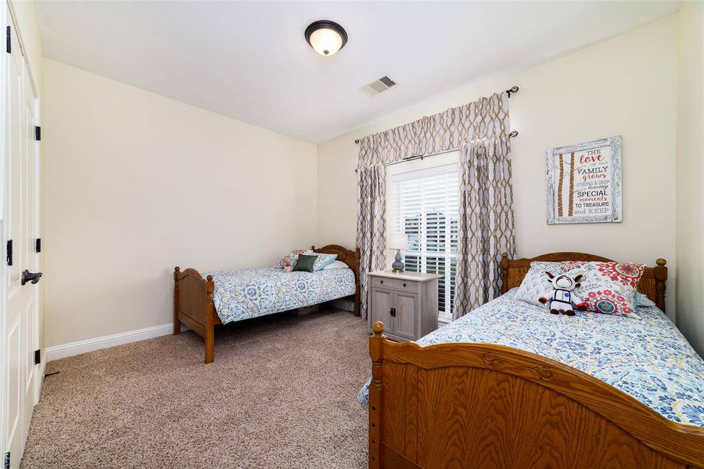 Secondary bedroom is spacious and bright, offering plush carpeting for warmth and comfort. Large closets provide plenty of storage, while neutral tones make it easy to personalize the space.