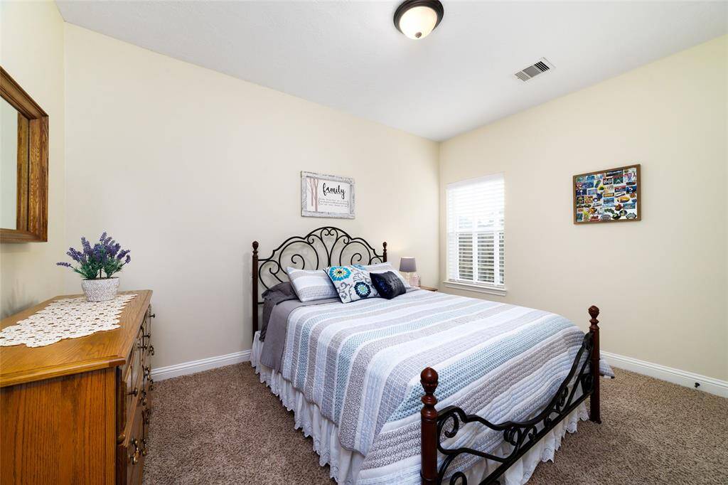 Secondary bedroom is spacious and bright, offering plush carpeting for warmth and comfort. Large closets provide plenty of storage, while neutral tones make it easy to personalize the space.