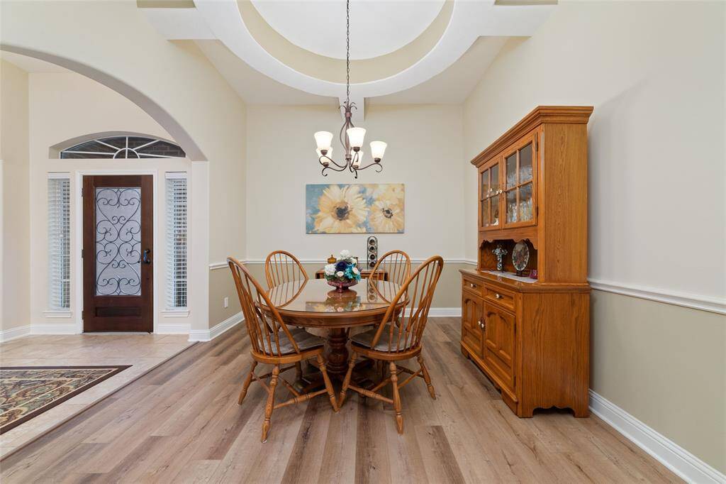 The elegant formal dining room showcases a beautiful architectural ceiling and chair rail, setting the stage for memorable gatherings.