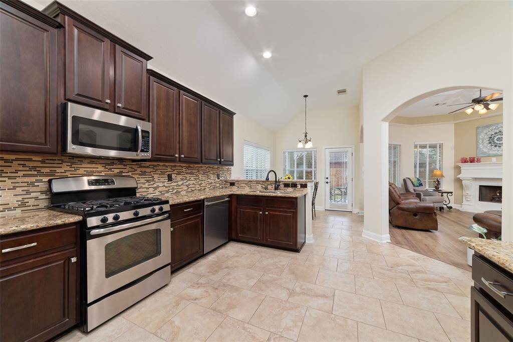 The gourmet kitchen shines with stainless steel appliances, sleek granite countertops, and a brand-new Bosch dishwasher for effortless cleanup.