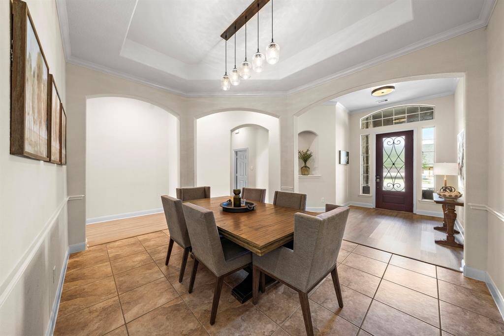 The formal dining room exudes sophistication with ample natural light highlighting the tile flooring and open layout. Ideal for entertaining, this elegant space harmonizes functionality and style, setting a graceful tone for memorable gatherings.