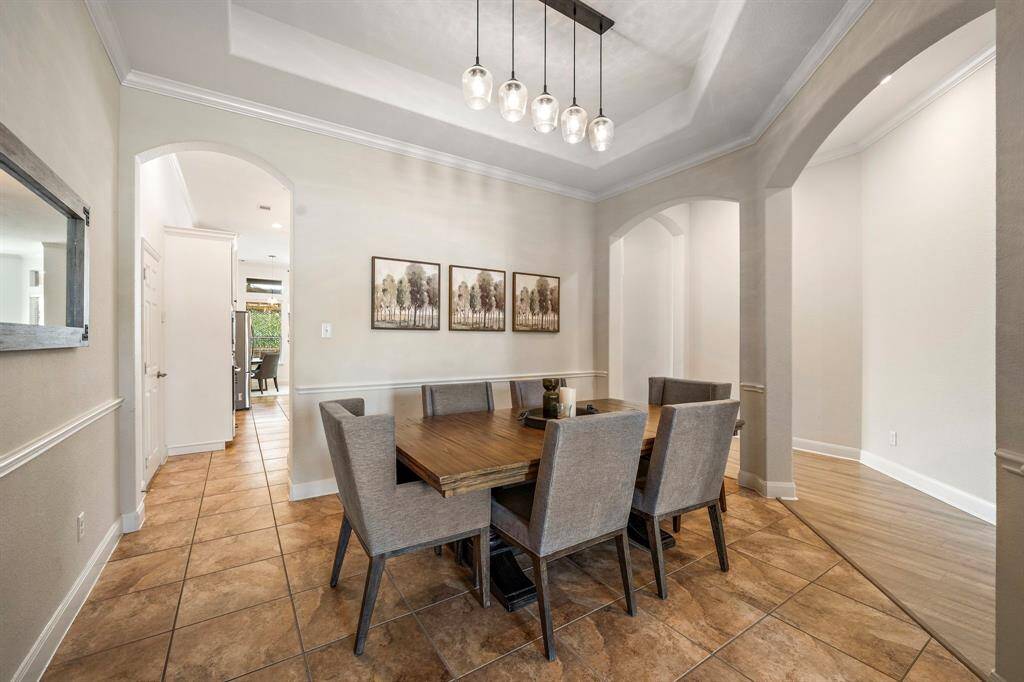 Discover a formal dining room characterized by abundant natural light and sophisticated elegance. The open layout, highlighted by tile flooring, offers ample space for entertaining, making it an ideal backdrop for both intimate dinners and festive gatherings.