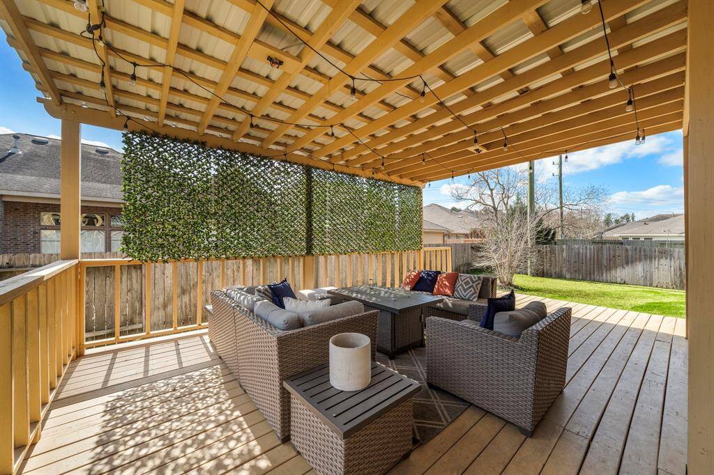 Overlooking the lush green space, the covered patio serves as an inviting extension of the home’s living areas.