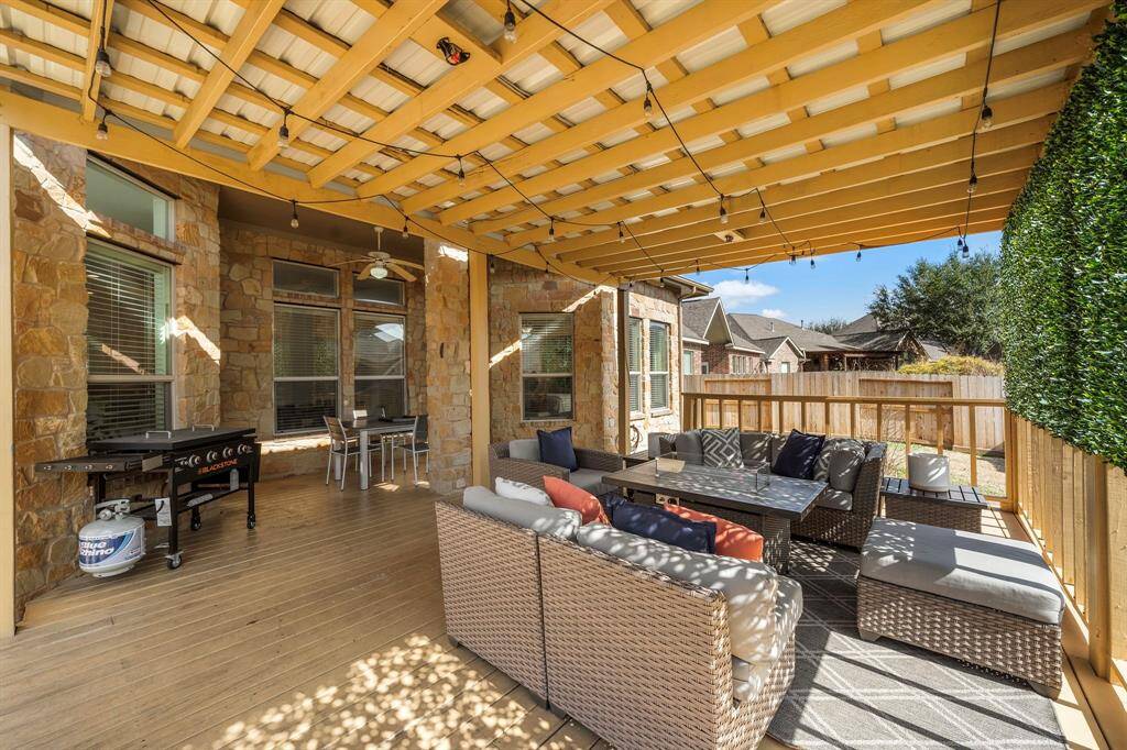 The cozy wood decking complements the stone accents of the home, providing a seamless transition between indoor comfort and tranquil outdoor living.