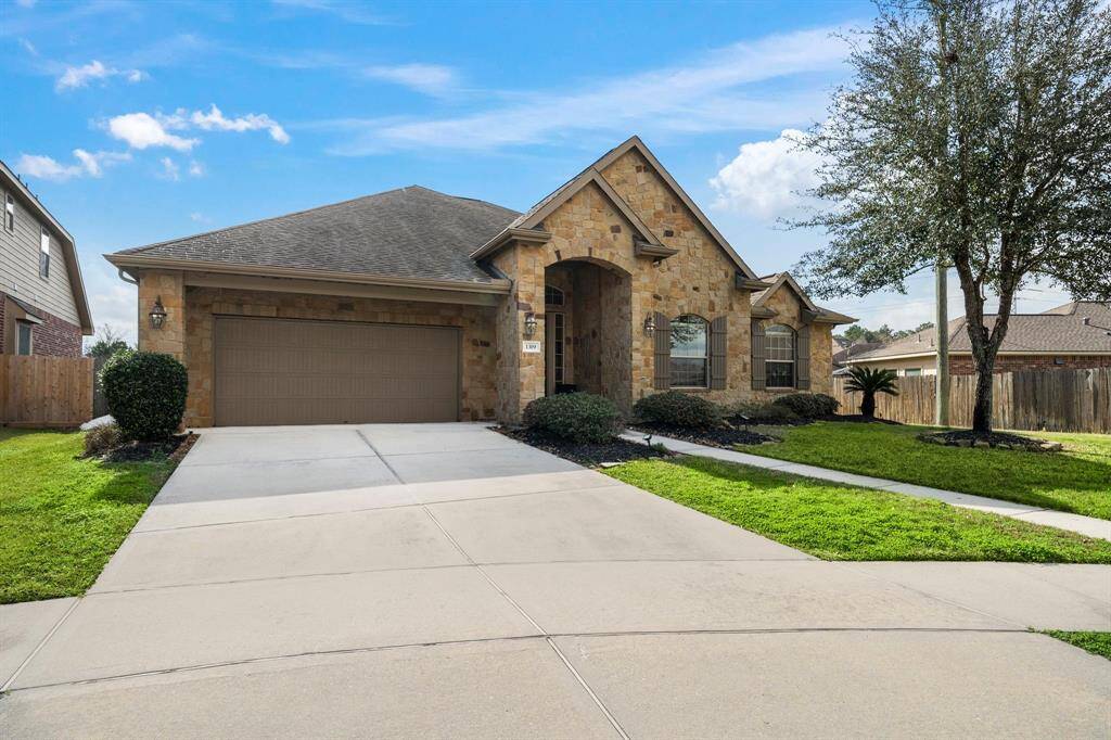 Situated on a serene cul-de-sac in Spring Trails, 1319 Allison Meadows Ct boasts a captivating brick and stone façade. The inviting covered archway leads to a welcoming entry. This home's exterior combines classic design with modern appeal, featuring a spacious 3-car tandem garage amidst lush landscaping, setting the tone for refined living in an amenity-rich neighborhood.