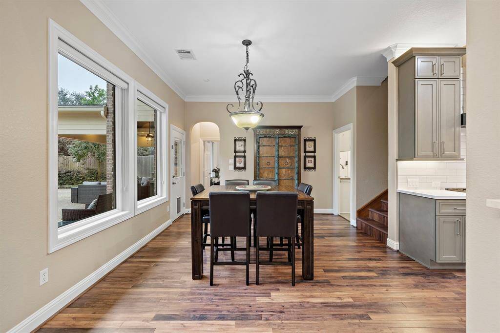 Sunlit and spacious, this breakfast area showcases tranquil backyard views through oversized windows, creating a seamless connection to the outdoors. Rich hardwood floors enhance the warmth of the space, while its open flow to the kitchen makes it a perfect spot for relaxed dining and everyday gatherings.