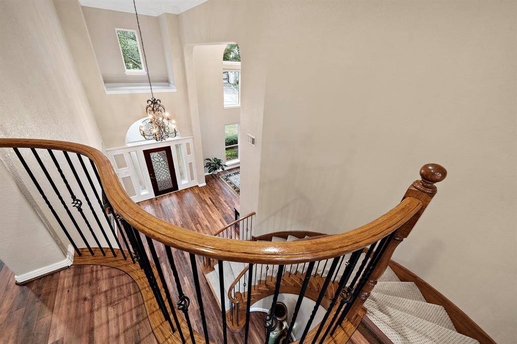 From the vantage point of the winding stairs, note the elegant chandelier and spacious, open layout of the entry. Elegant architectural details and newer, energy-efficient windows create a bright space. Hardwood flooring extends through the entry.