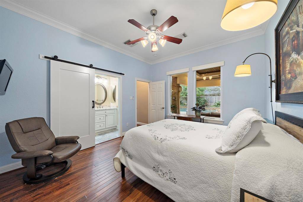 The 1st floor secondary guest bedroom features its own ensuite bath with standing shower. Large windows offer views of the backyard oasis.