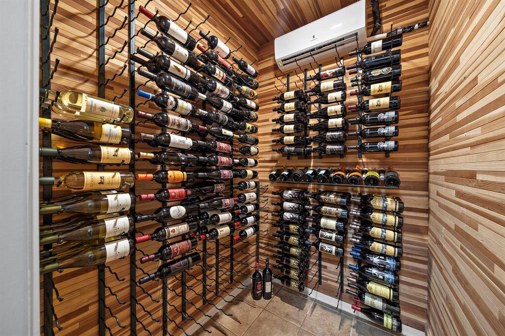 Showcasing a climate-controlled wine room, complete with stylish cedar wood paneling and individual bottle storage. Wine aficionados will enjoy the extensive built-in wine racks.