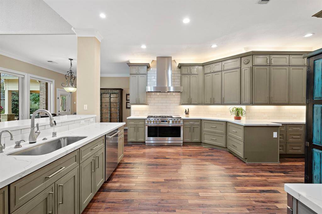 This remodeled kitchen boasts Monogram professional-grade stainless steel appliances, including a 48' gas range w/ dual ovens and sleek vent hood. Quartz countertops complement the soft-close cabinetry, while the spacious layout encourages seamless entertaining with climate controlled wine room nearby.