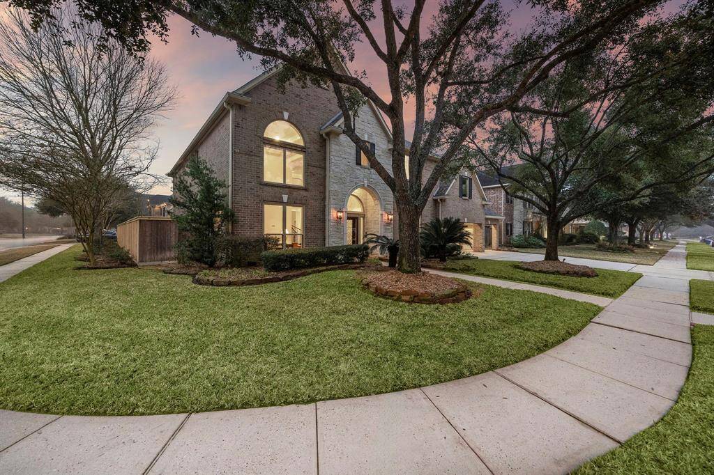 This updated, two-story home located at 14618 Logan Falls Lane boasts a brick and stone facade on a corner lot. Refined landscape lighting enhances the architecture and established foliage.