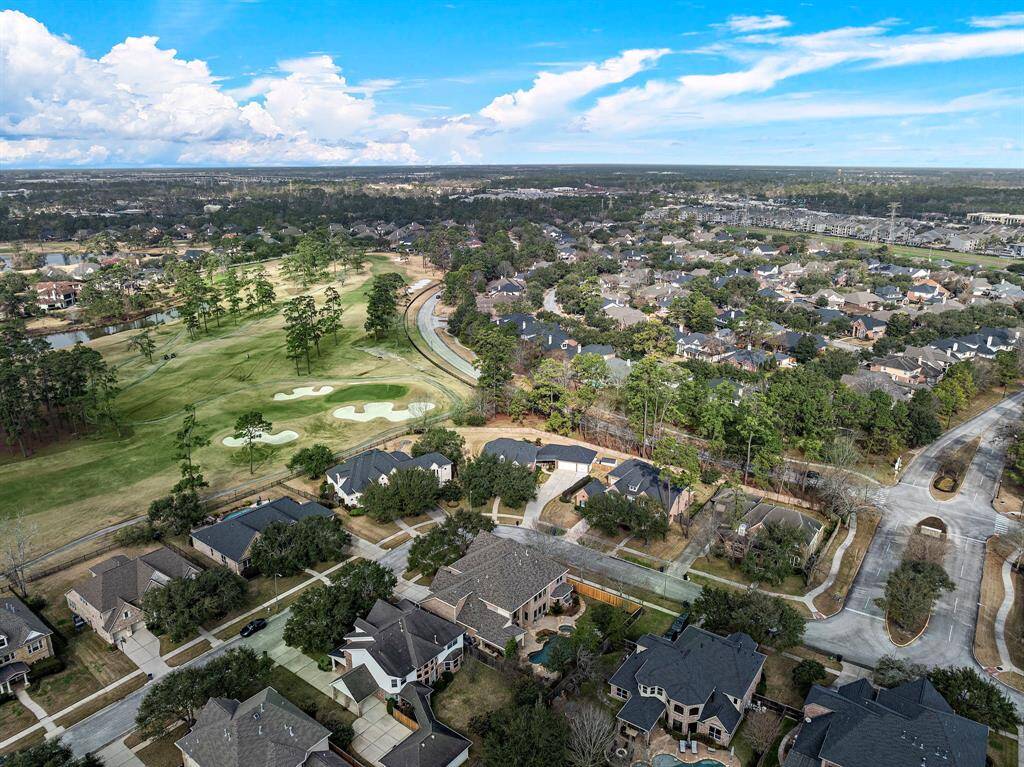 Expansive aerial views showcase the picturesque Fall Creek community, with tree-lined streets, lush green spaces, and the prestigious Golf Club of Houston just moments away. A serene suburban retreat with convenient access to top-tier amenities.
