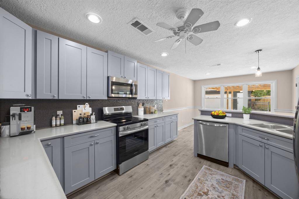 Beautifully updated kitchen with contemporary color palette with new stainless steel appliances, subway tile backsplash, new countertops and a nice view of the backyard through the new double paned windows.
