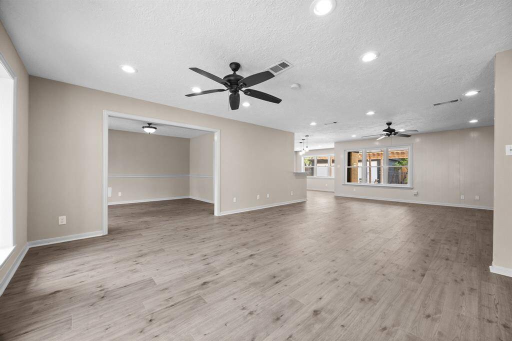 Entering this well lit spacious living area features contemporary laminate flooring, neutral wall colors, recessed lighting and two new ceiling fans.