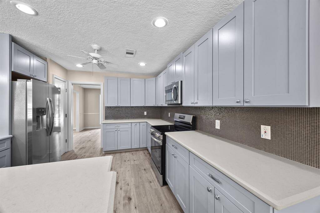 Kitchen boasts generous counter space and new cabinetry for amble storage.