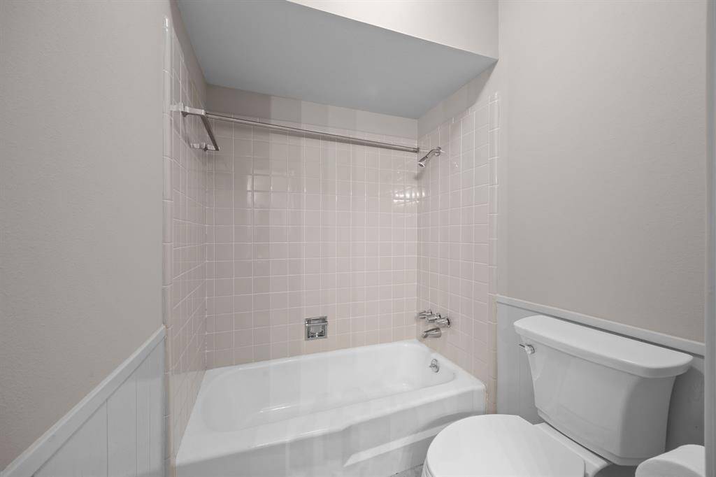 Secondary bathroom has new tile, toilet and bath tub.