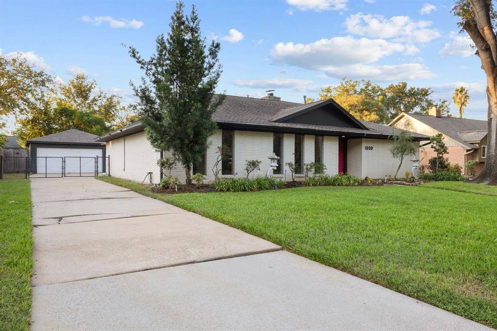 Long driveway with gate runs along the side of the home to a detached two-car garage and gate adding a safety feature for the pool just around the corner.