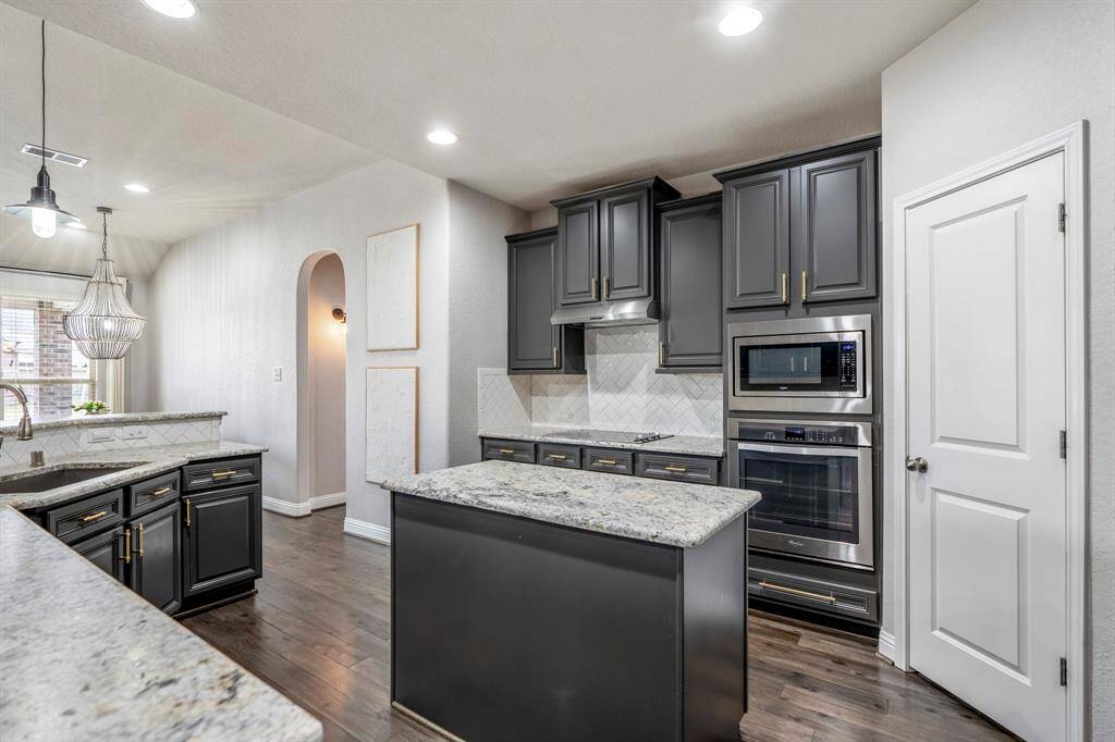 You will love the details of this kitchen! It features brushed granite counters with an upgraded leathered finish, gold cabinet hardware, walk-in pantry, LED overhead lighting, a large single basin sink with sleek faucet, and upgraded built in SS appliances.