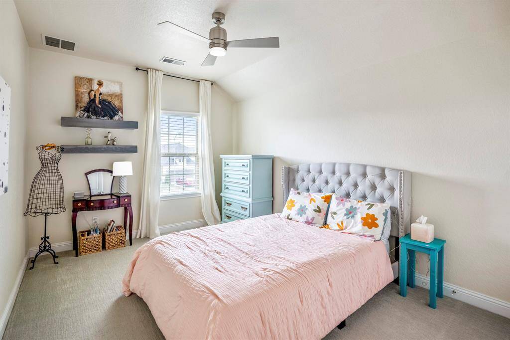 Bright and inviting, this spacious secondary bedroom offers plenty of room for relaxation and personalization, featuring blush carpet, modern ceiling fan, and bright natural light.