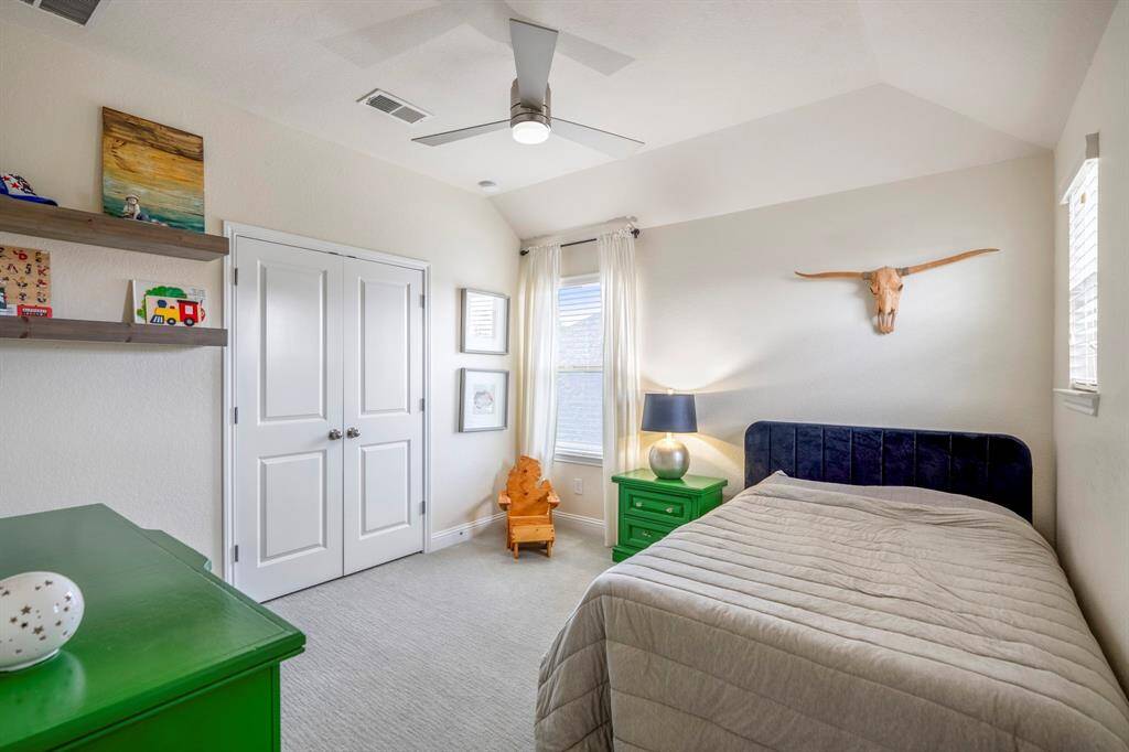 Another spacious secondary bedroom featuring bright natural light, large closet, plush carpet, and ceiling fan.