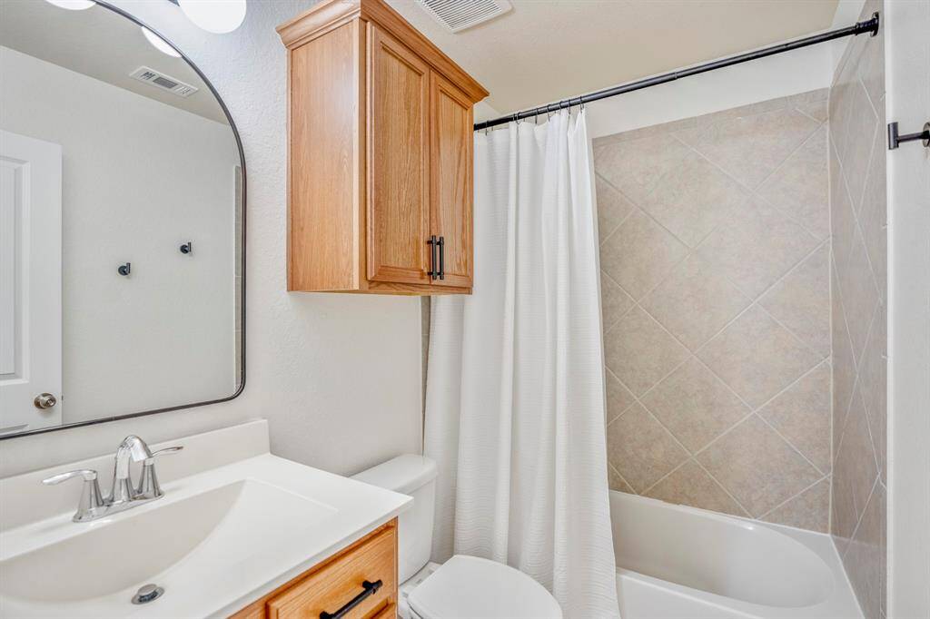 Relax and unwind in this beautifully designed secondary bathroom, featuring white countertops and a spacious combination tub and shower for the ultimate in comfort and style.