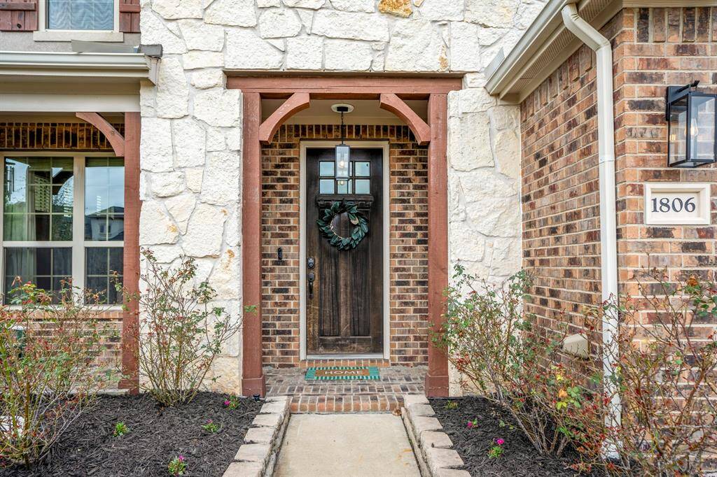 This charming entryway features a spacious front porch with wooden details, an 8ft front door, beautiful stonework, and a warm, inviting ambiance. Who wouldn’t love coming home to this?