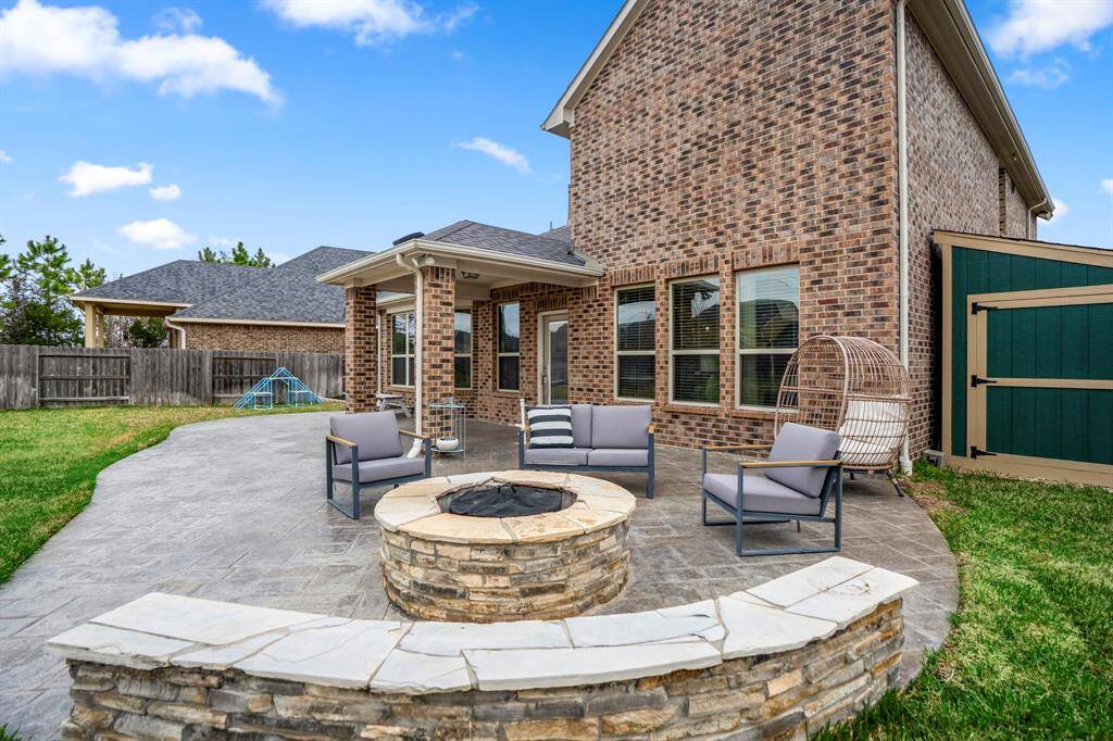 This stunning firepit with a built in stone bench is the perfect spot for cozy nights under the stars, making it an ideal space for entertaining or enjoying quiet moments with family.