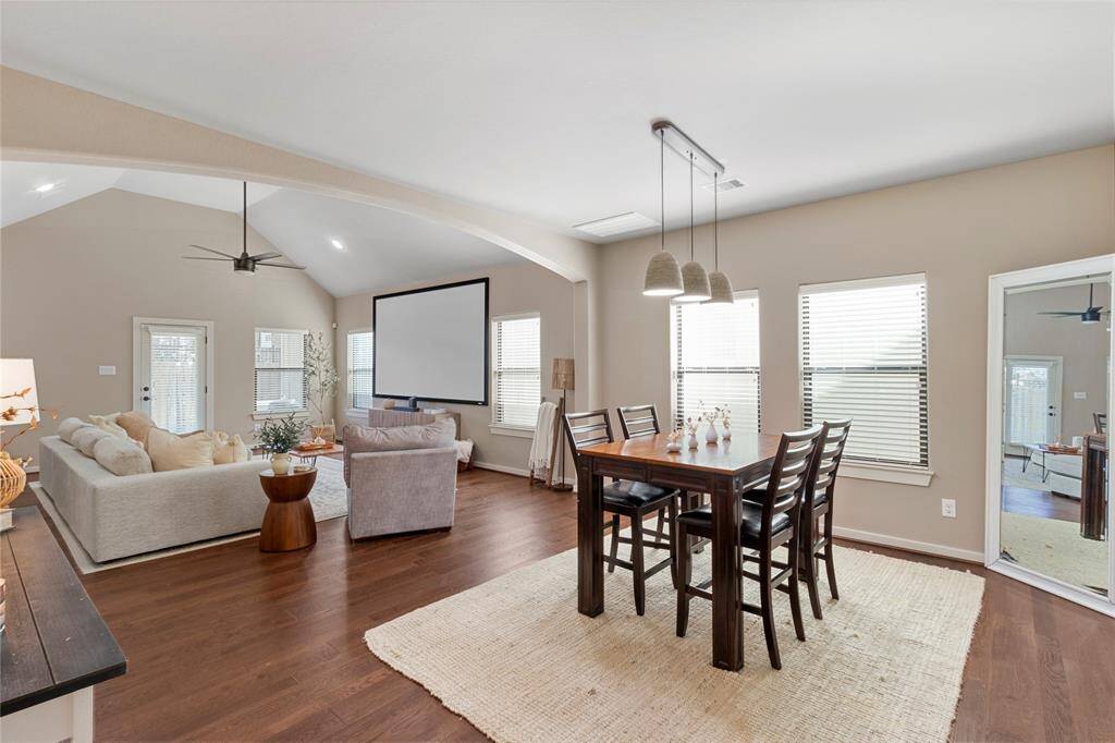 This open-concept living and dining area features hardwood floors, neutral walls, and abundant natural light. It includes a cozy seating area with room for a large sectional sofaand  a dining table with seating for six.