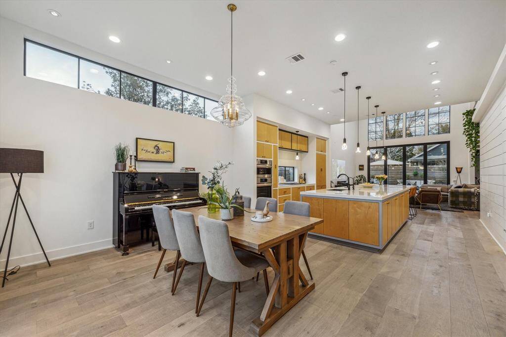 Formal dining room with both recessed and glass pendant lighting. The transom window allows in additional natural light while leaving a blank canvas to display your most prized art pieces.