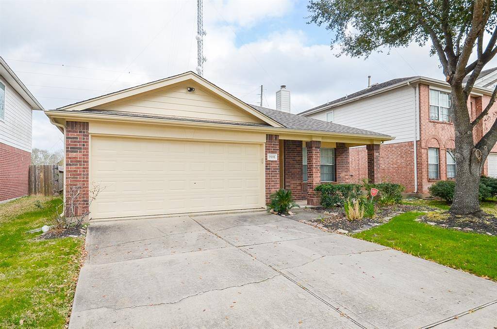 This photo shows a charming single-story brick home with a two-car garage, a neat front yard, and a covered entryway, perfect for comfortable suburban living.