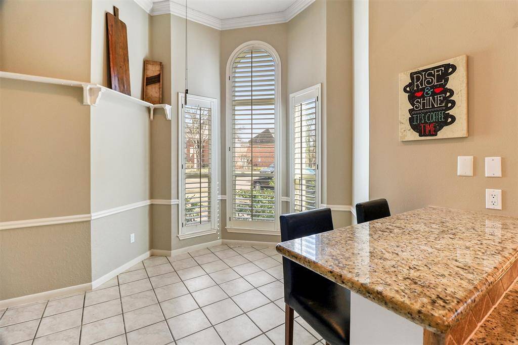 Breakfast room offers large windows with shutters for lots of natural light, breakfast bar, chair rail, and high shelving for displaying your favorite keepsakes.