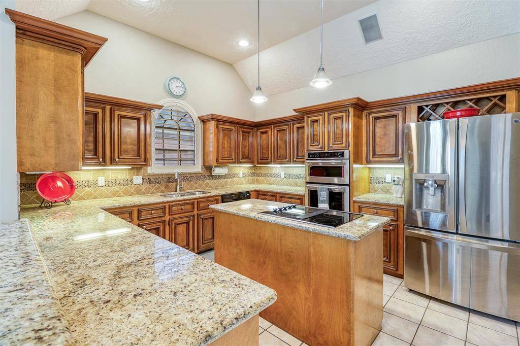 Another view of beautiful large kitchen featuring under cabinet lighting, and again lots of granite counter space for cooking and entertaining.  Please note: refrigerator conveys with home.