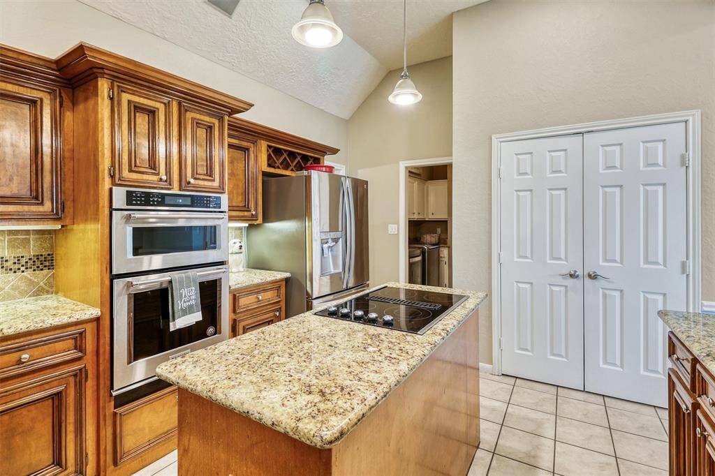 View of double door pantry featuring upgraded slide out shelving, and view into utility/laundry room.