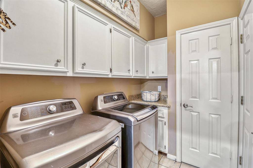 Utility/laundry room features lots of cabinets for storage and storage closet.  NOTE...washer and dryer convey with property.