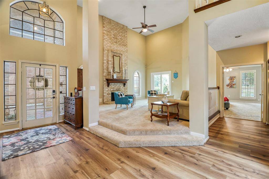 View from atrium doorway showing 2-story foyer and elevated family room and walkway to large primary bedroom.