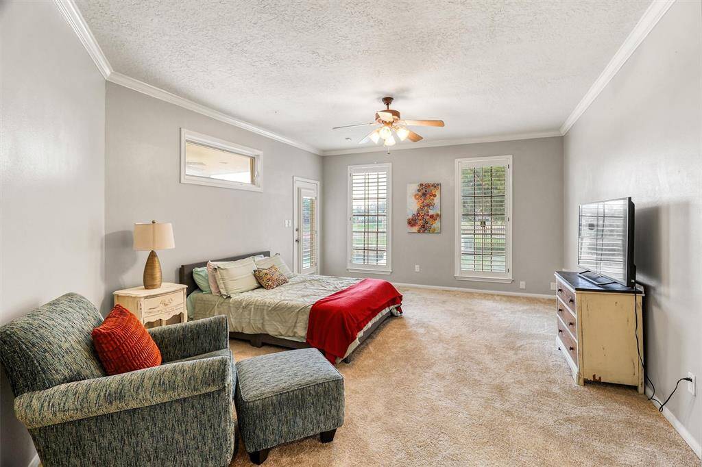 Large primary bedroom features fresh paint and carpet, large floor to ceiling windows with shutters for lots of natural light, and private doorway to backyard covered patio and pool.