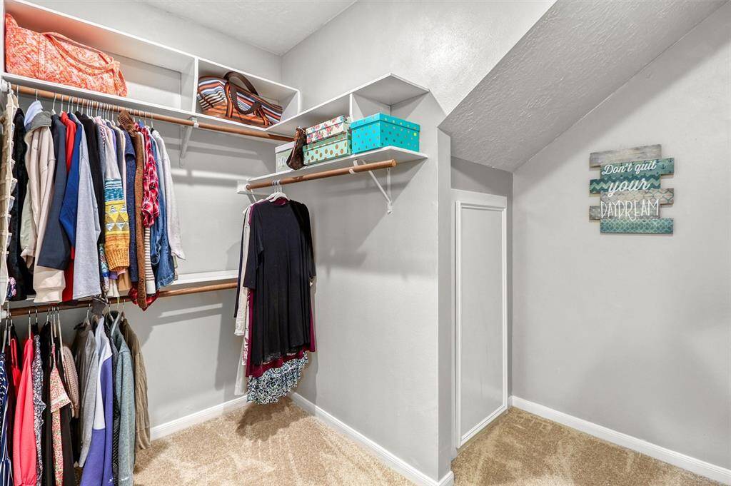 Large primary closet showing doorway into cedar closet/storage area.