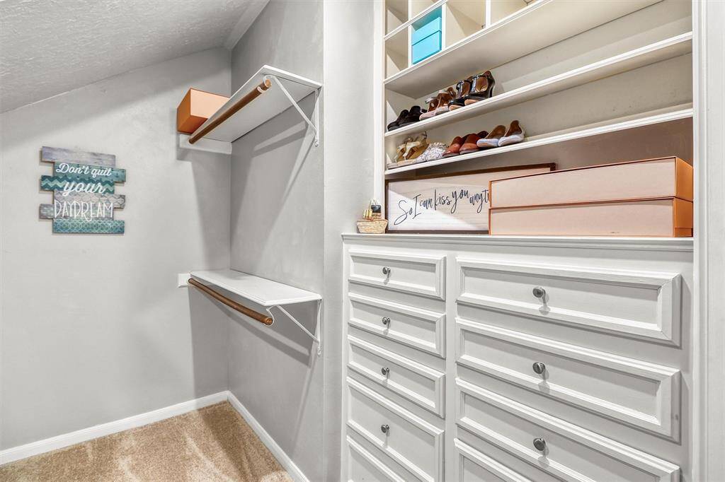 Large primary closet also features built-in chest of drawers and shelving.