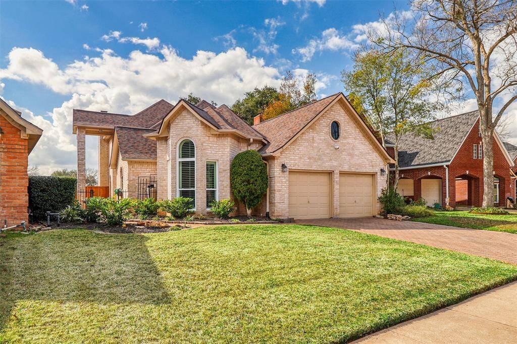 Another view of beautiful curb appear of this uniquely designed brick home offering large mature trees and beautifully manicured landscaping.