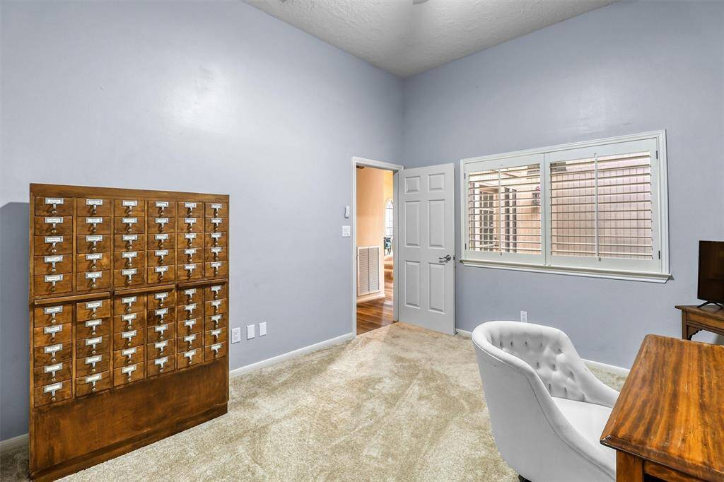 Another view of first floor secondary bedroom currently being used as a study and features large window with shutters, fresh paint and carpet.